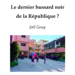 La photo de plusieurs bâtiments de couleur rose et ocre. Des enfants noirs en uniforme scolaire sont réunis dans la cour. L'un deux porte le drapeau haïtien. C'est la couverture du livre "Le dernier hussard noir de la République ?"